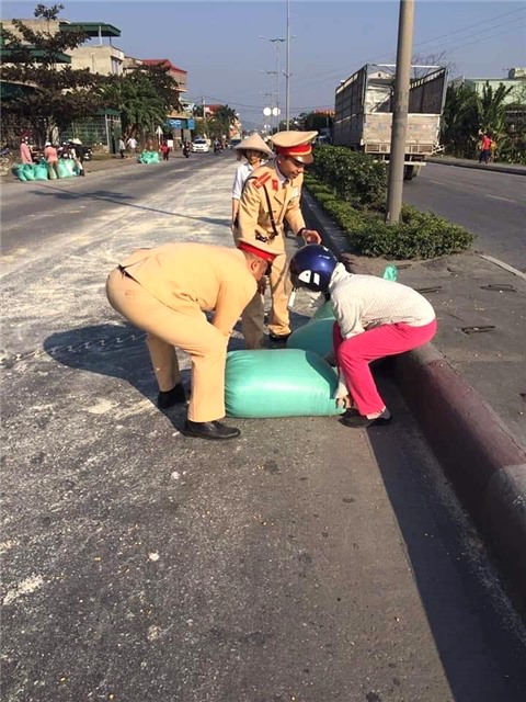 Lực lượng chức năng cùng người dân TP Uông Bí: Giúp thu gom 5 tấn ngô bị rơi ra đường quốc lộ